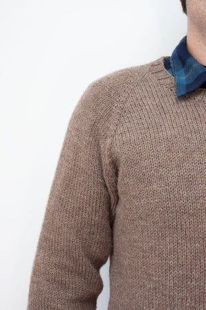 close up of raglan increases on hand knit sweater worn by a man in a flannel blue collared shirt